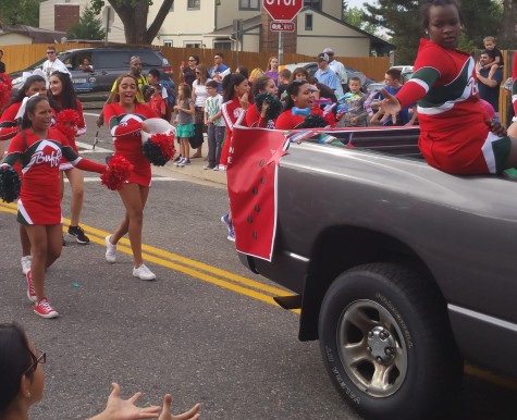 Beautiful Cheerleaders sing out a chant while kids on the side eagerly reach out for candy.
