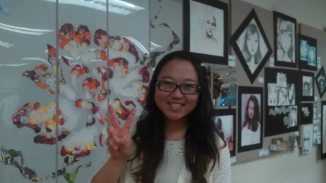 Ria Kim standing next to her artwork