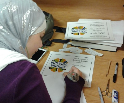 Klaibou writes her group's names in Arabic and Hebrew on their Building Bridges awards