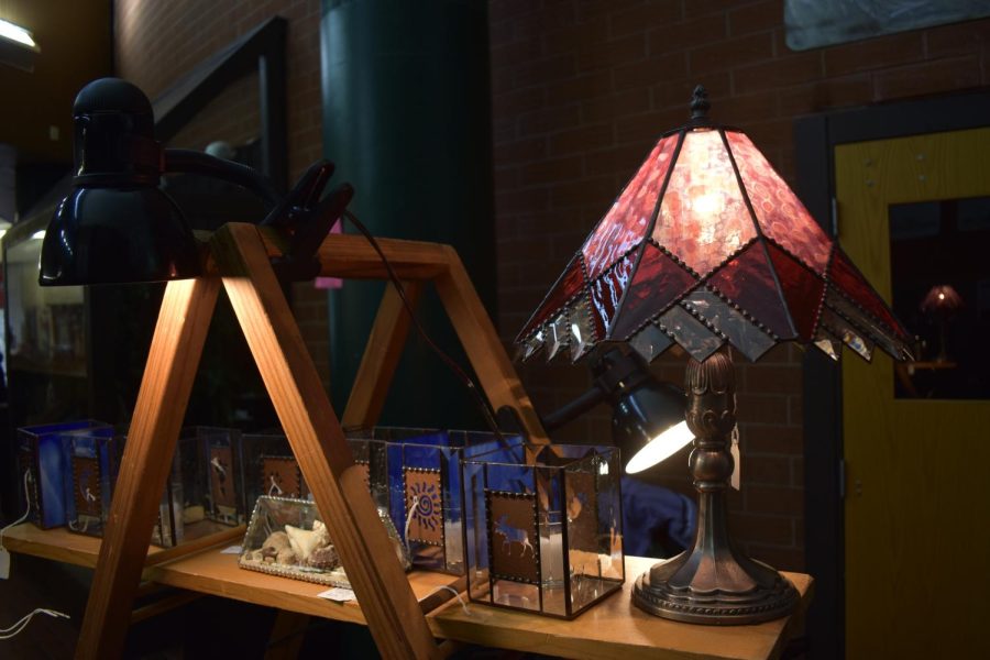 A stained glass lamp and other lamps on a table to be sold during the Craft Fair.