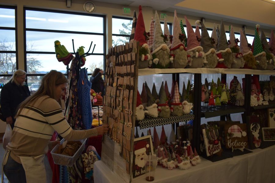 A vendor set up their store filled with gnomes, earrings, and other holiday crafts.