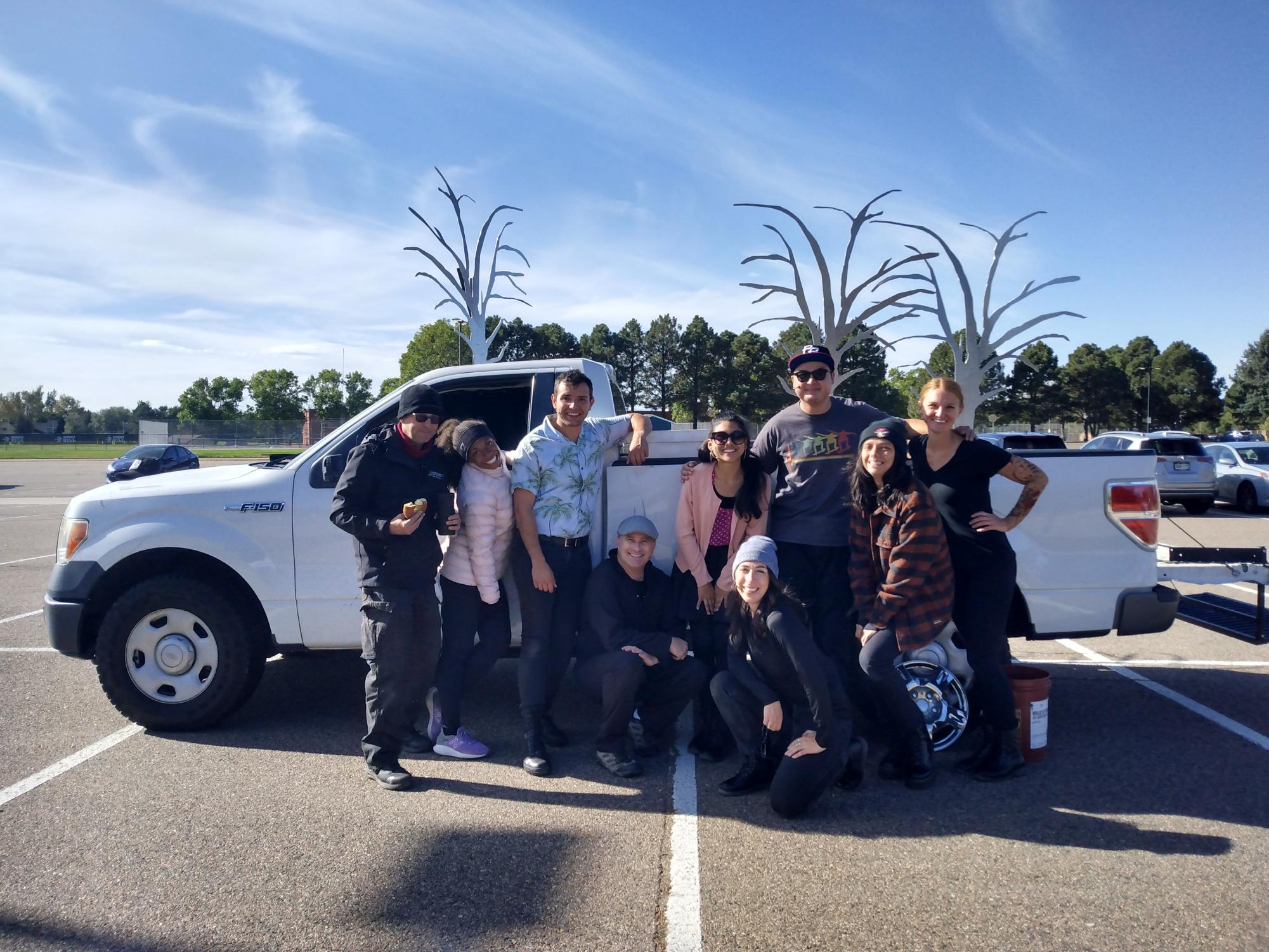 From left to right: Stuart Barr, Jasmyne Pierce, Christian Ray Robinson, Justin Walvoord, Iliana Barron, Shannon Altner, Grant Bowman, Adara Baltazar, and Chloe McLeod pose for a post-play photo in front of the scene-ready truck. 